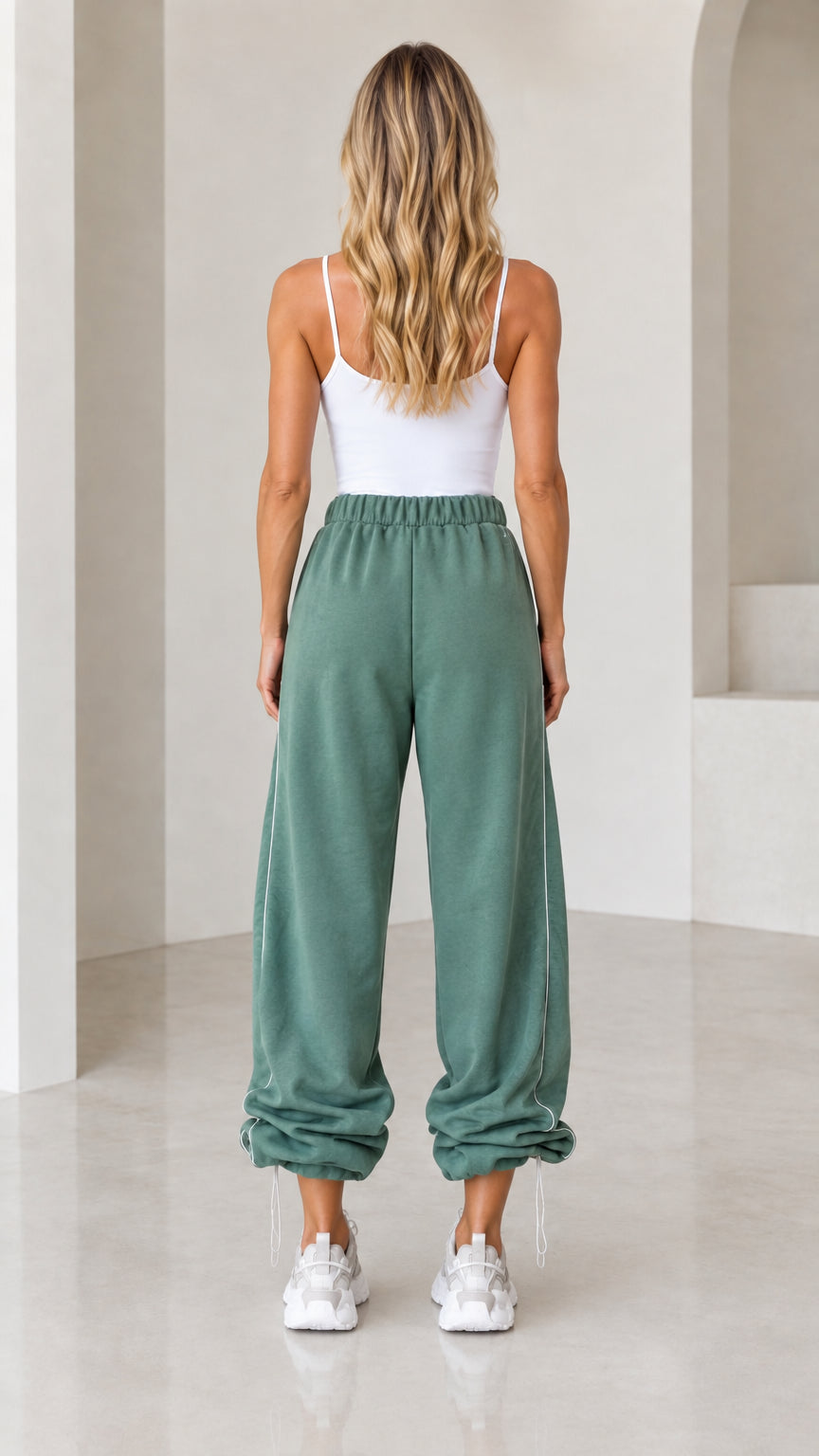 Back view of model wearing sage green wide-leg joggers with gathered ankles