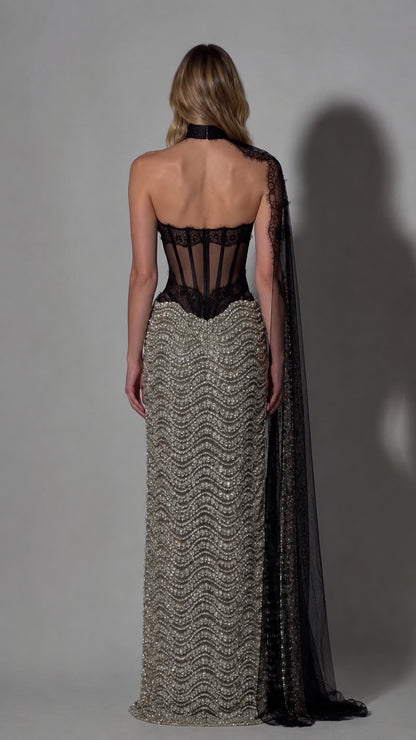 Back view of woman wearing sheer boned corset evening gown with lace cape detail