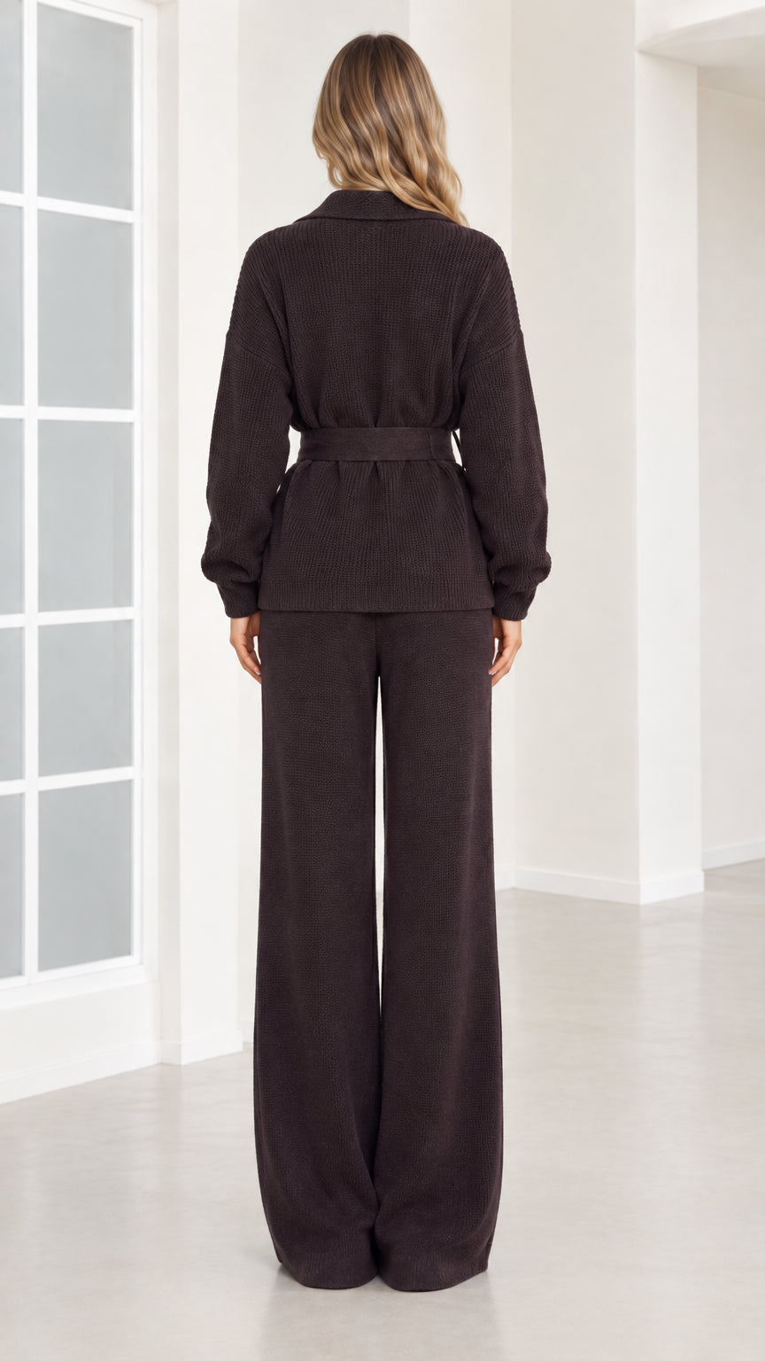 Back view of woman wearing dark brown ribbed knit belted top and wide-leg trousers
