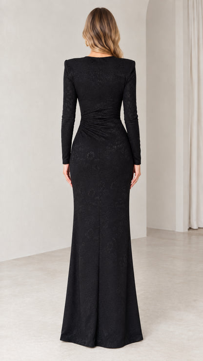 Back view of woman wearing black jacquard evening maxi dress with structured shoulders