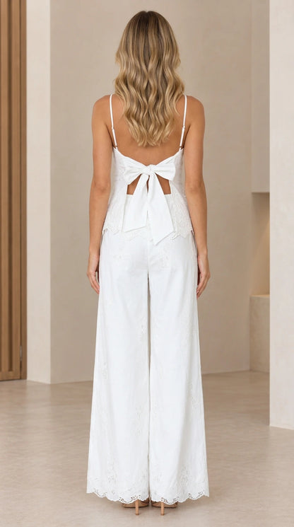 Back view of model showing the tie-back bow detail on white peplum top