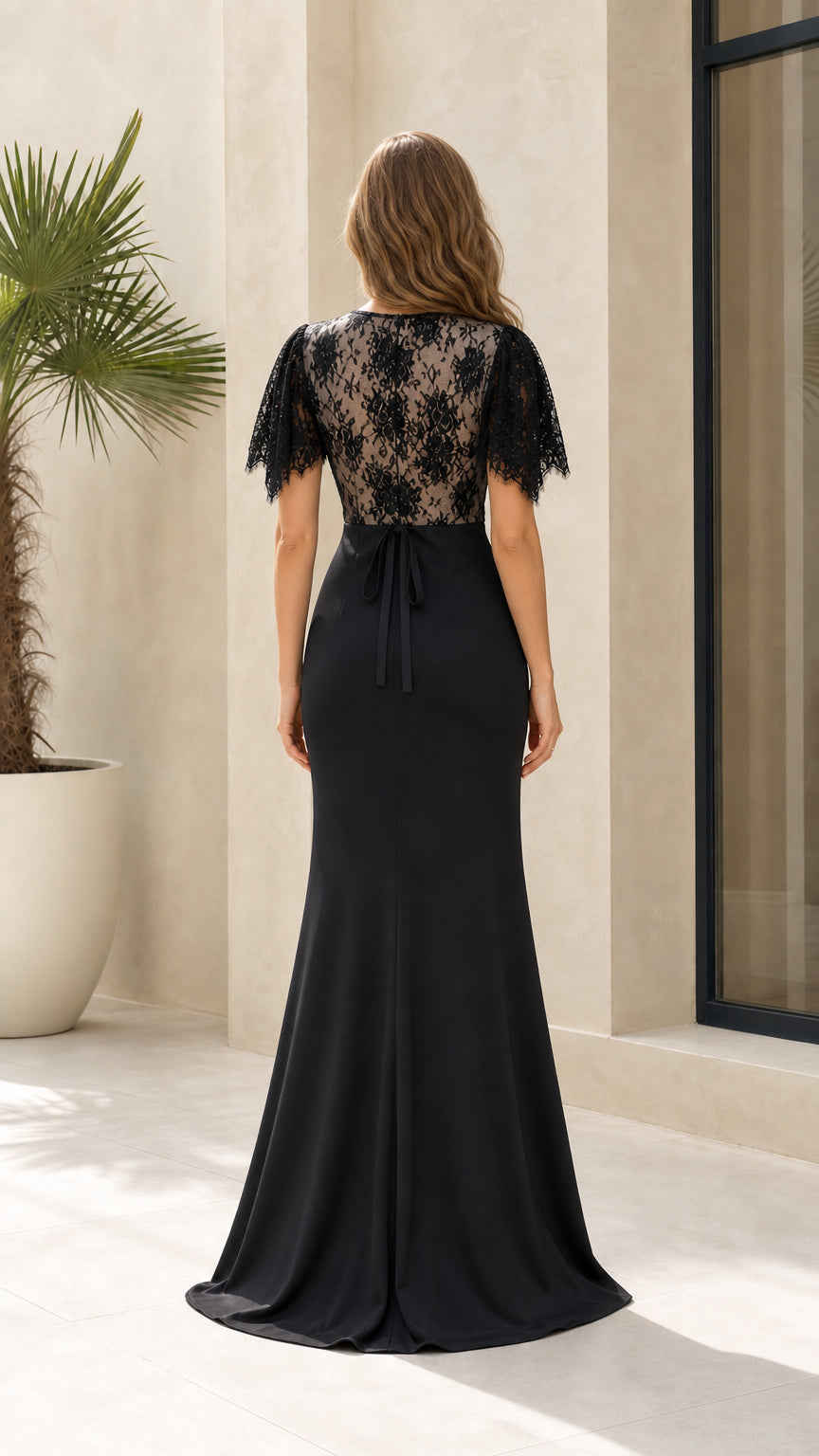 Back view of model wearing black floor-length formal gown with lace back detail