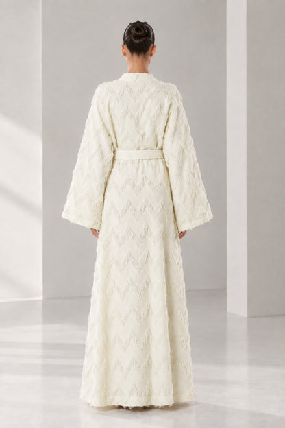 Back view of woman wearing cream belted maxi robe with textured chevron weave