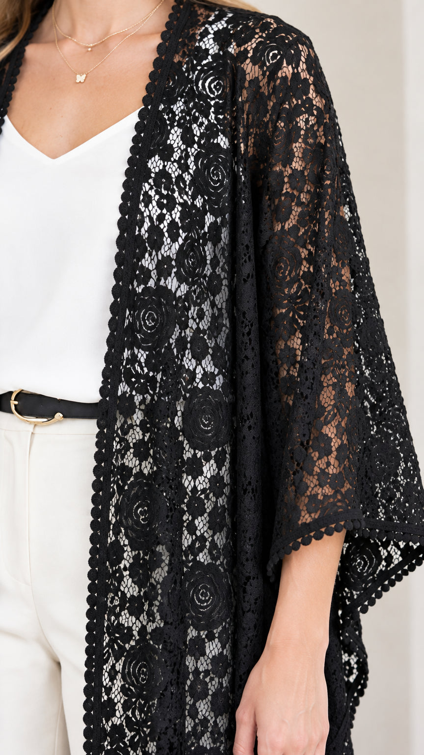 Close-up detail of sheer floral lace fabric and scalloped border on black duster