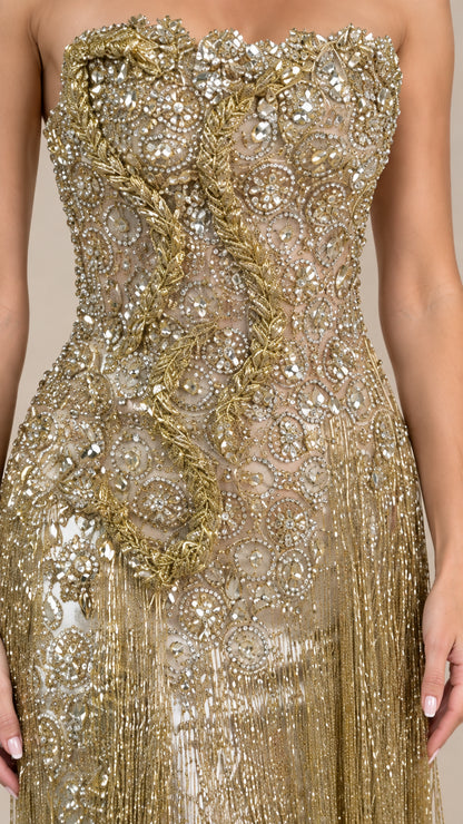 Close-up detail of ornate beadwork and gold fringe embroidery on bodice
