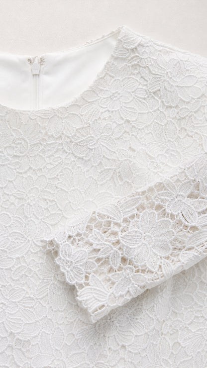 Close-up detail of white floral lace neckline and sleeve cuff