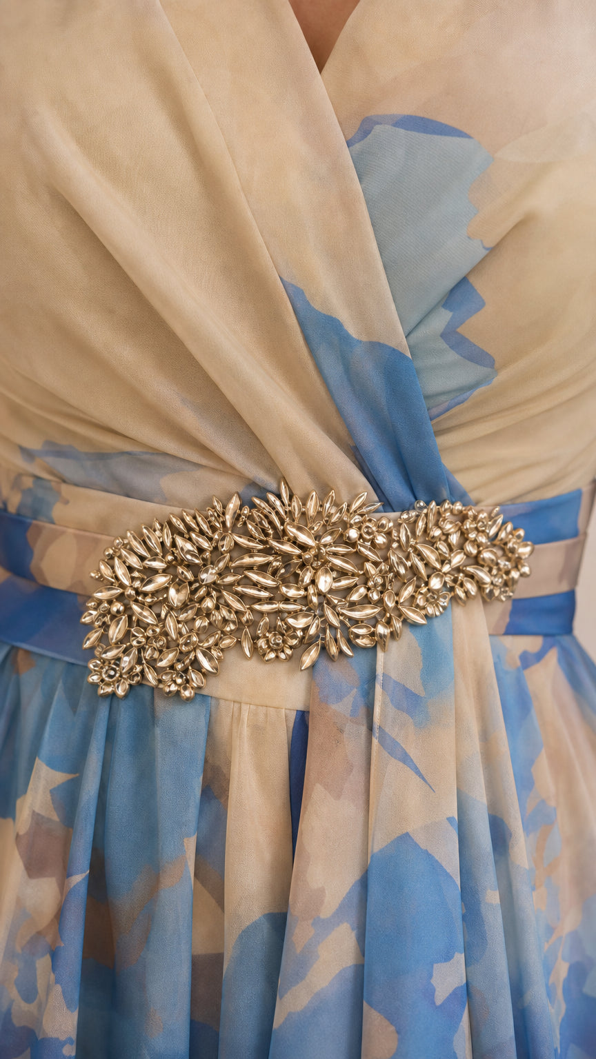 Close-up of crystal embellished waist appliqué and sheer beige and blue chiffon fabric
