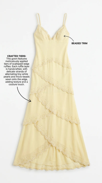 Flat lay detail of pastel yellow gown showing beaded V-neck and scalloped tiers