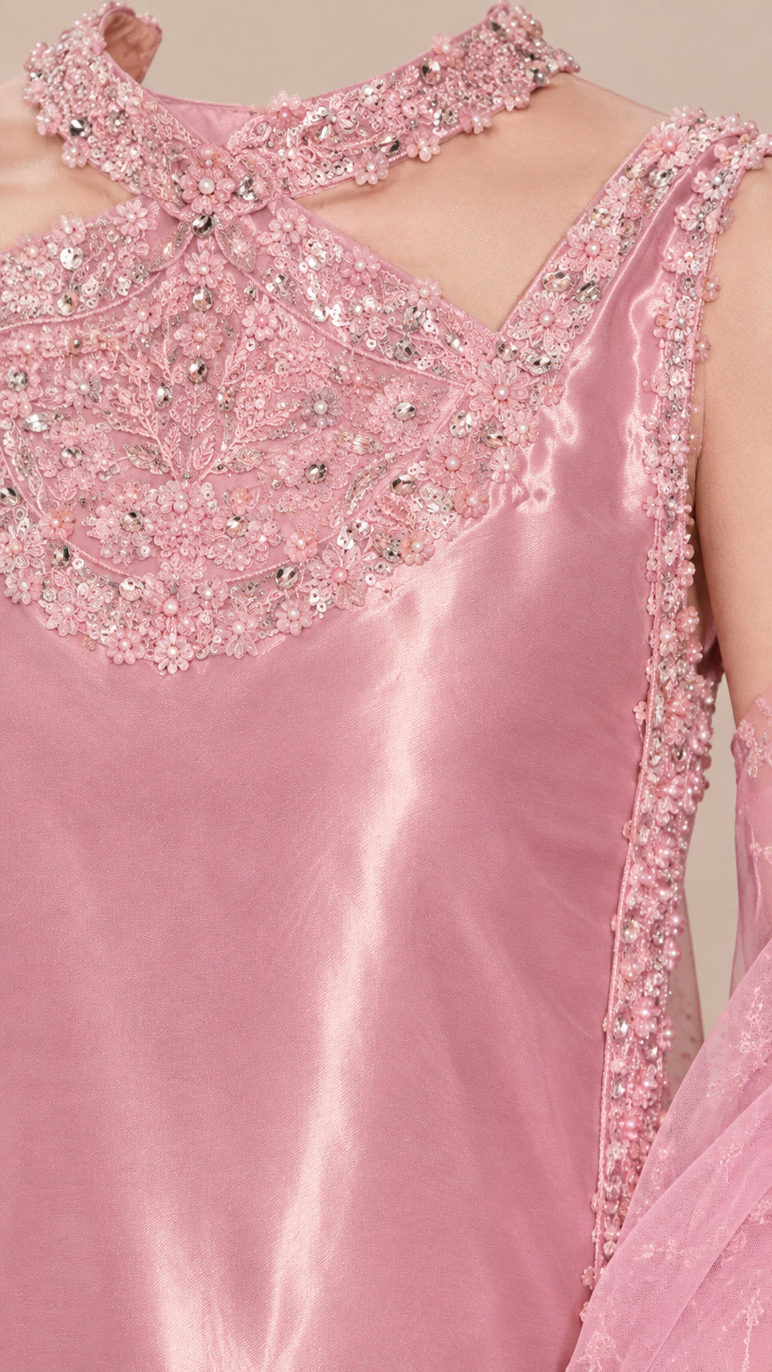 Close-up detail of ornate beaded neckline and sequin embroidery on blush pink satin dress