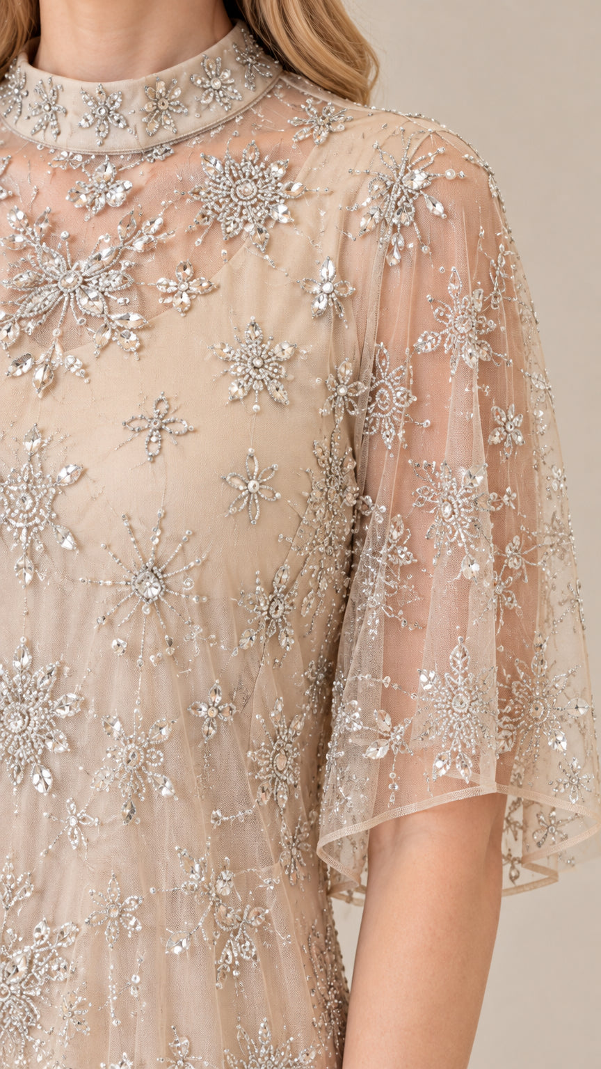 Close-up detail of champagne sheer neckline and starburst sequin beading