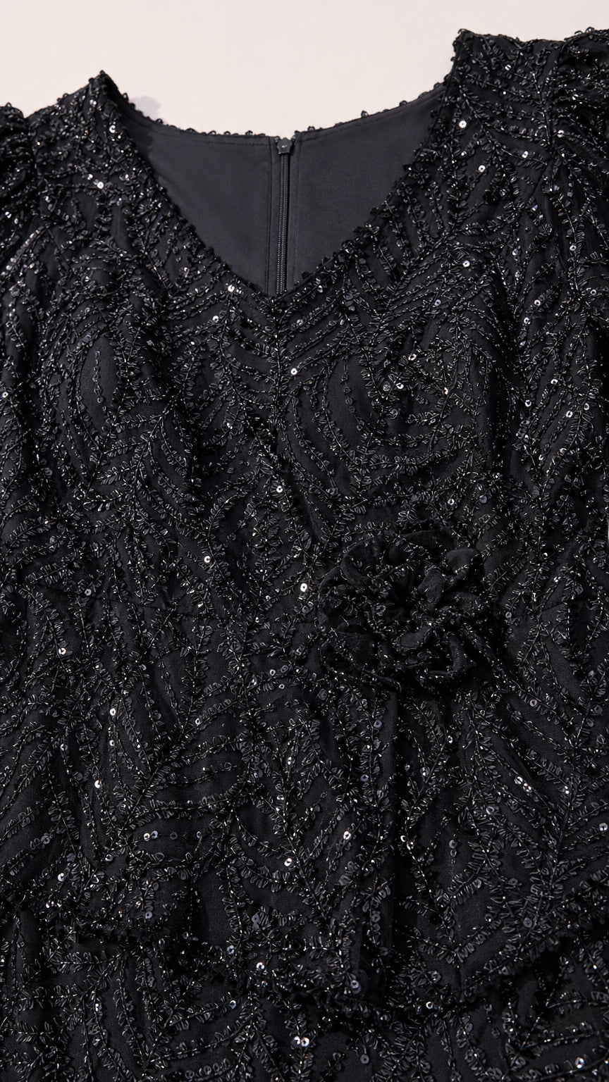 Close-up texture of black floral sequin embroidery and peplum detail