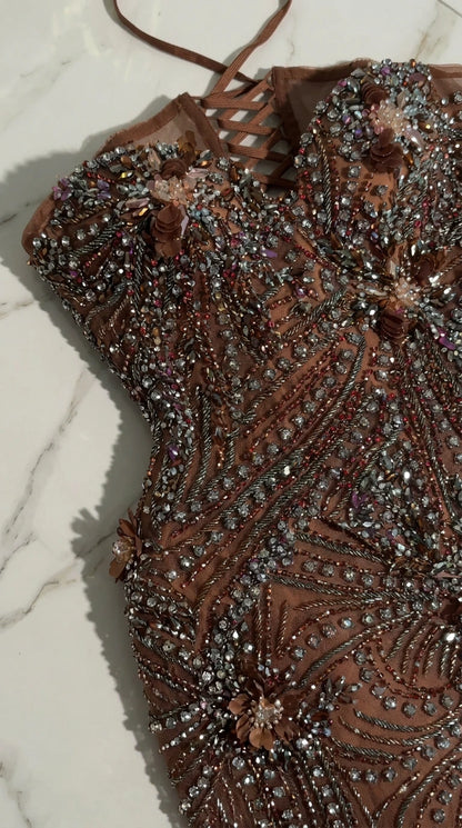Detailed close-up of lace-up back and intricate beadwork with floral accents
