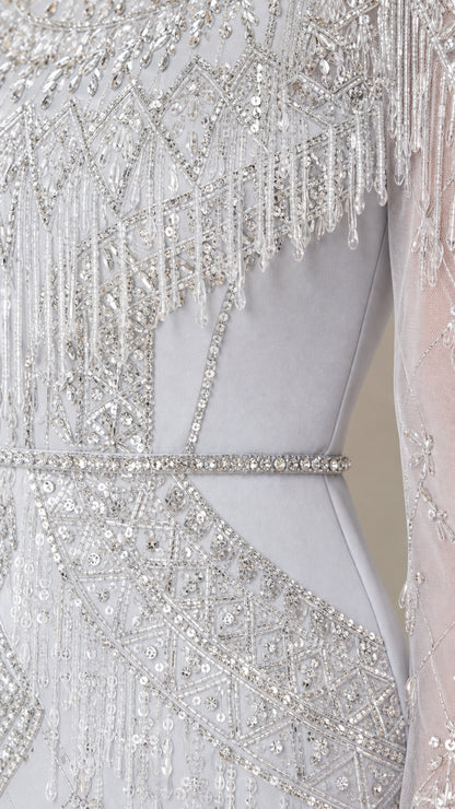 Close-up detail of silver sequin pattern, beaded fringe, and waistline trim