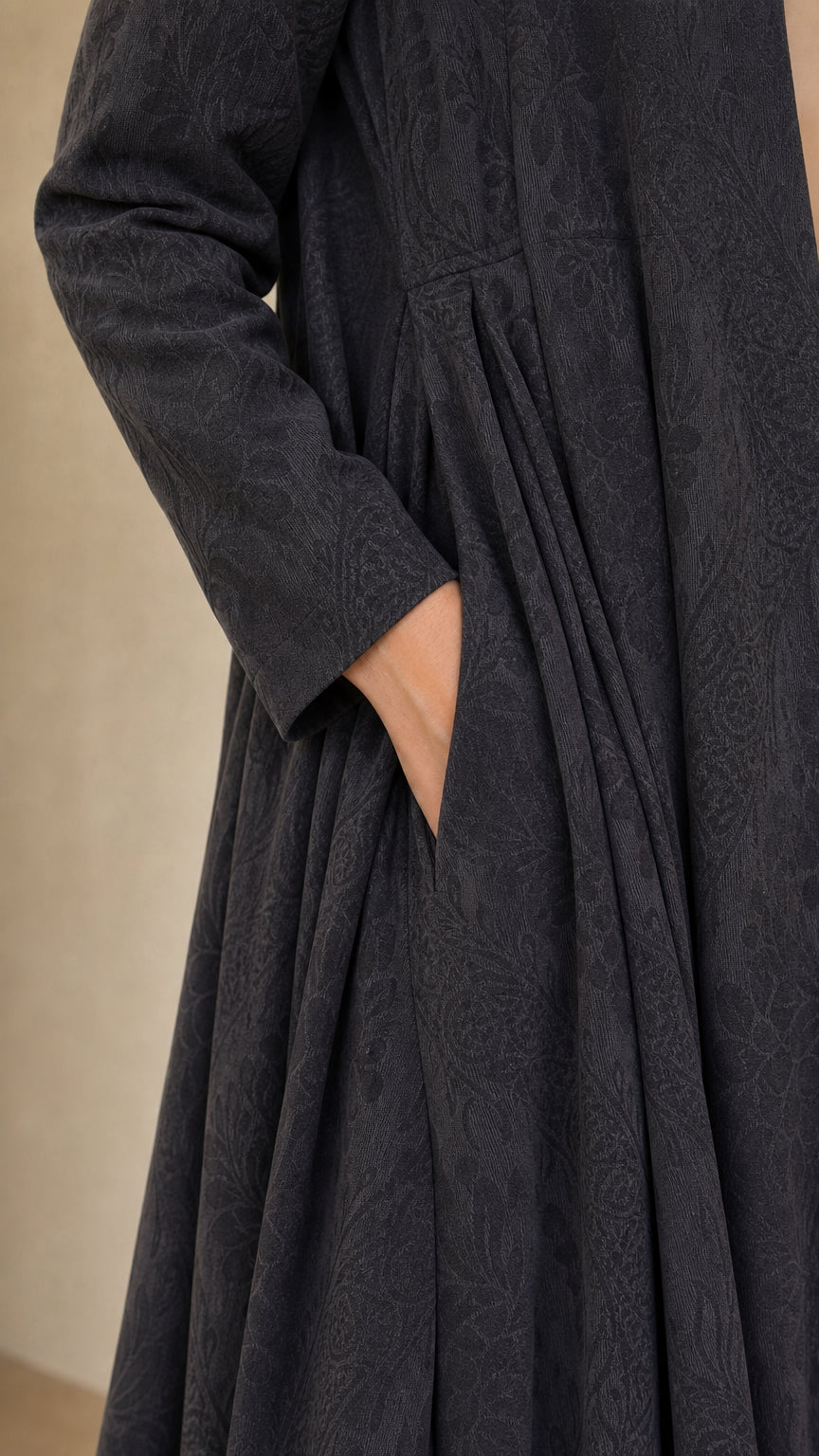 Close-up detail of charcoal grey jacquard textured fabric, side pocket, and waist pleats