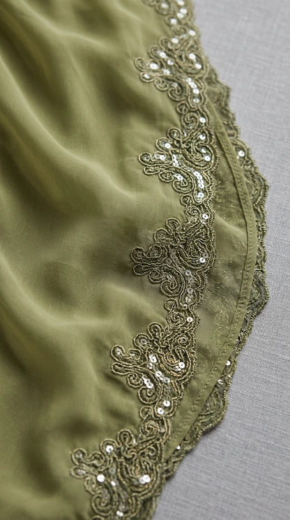 Close-up of olive green chiffon tier hem with embroidered sequin trim