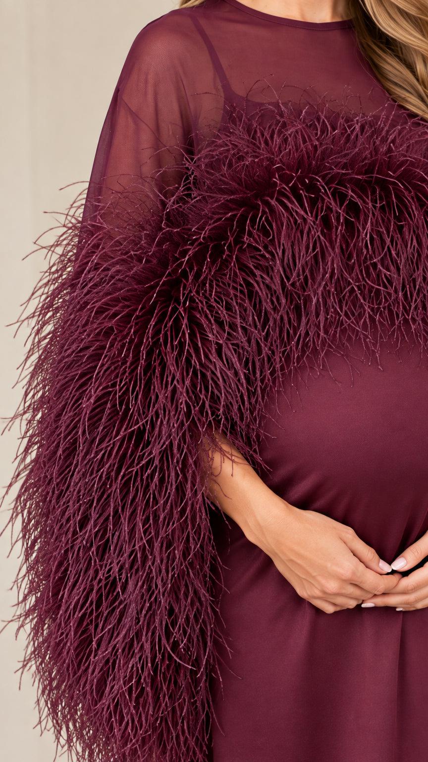 Close up texture of burgundy feather accents and sheer illusion bodice