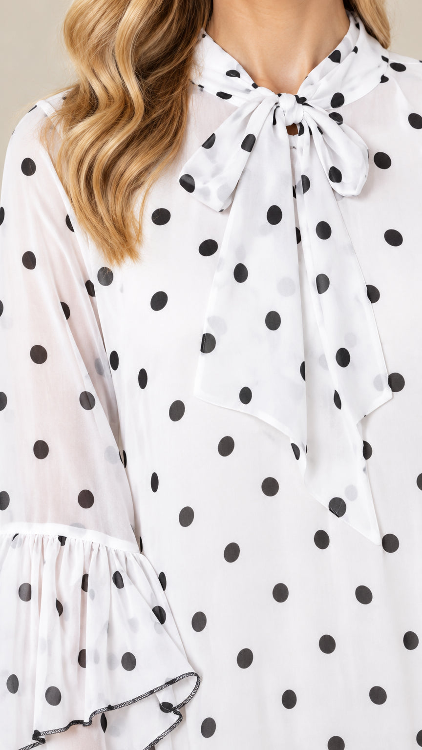 Close-up of bow tie collar and polka dot pattern fabric with ruffle accents