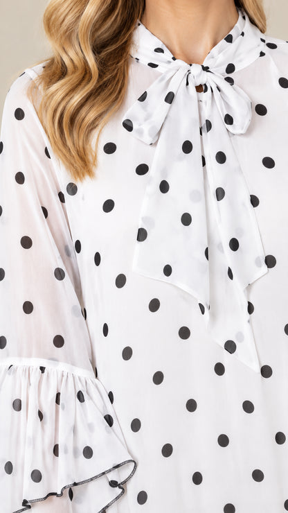 Close-up of bow tie collar and polka dot pattern fabric with ruffle accents
