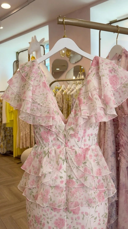 Close-up of the ruffled bodice and plunging neckline of the pink floral gown on hanger