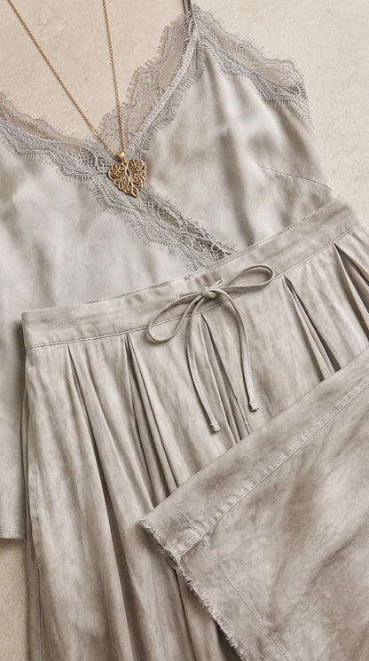 Close-up of delicate lace trim and drawstring waist on silver grey dress