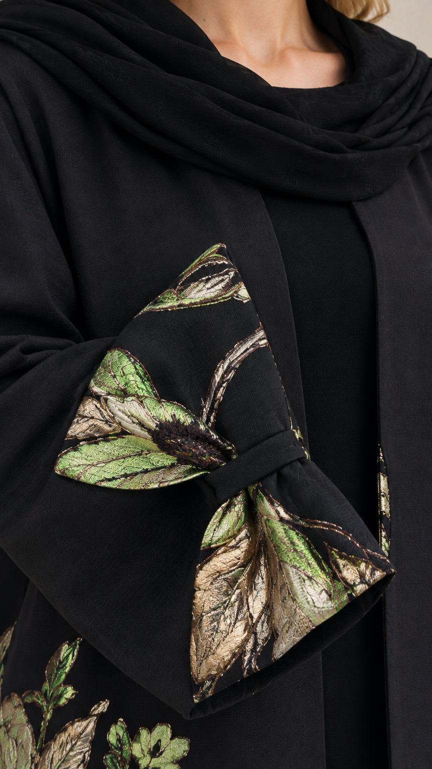 Close-up detail of Black abaya sleeve cuff with metallic botanical embroidery and bow accent
