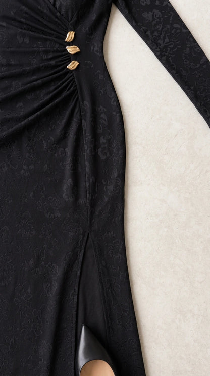 Close-up of side ruching, gold button details, and slit on black jacquard fabric