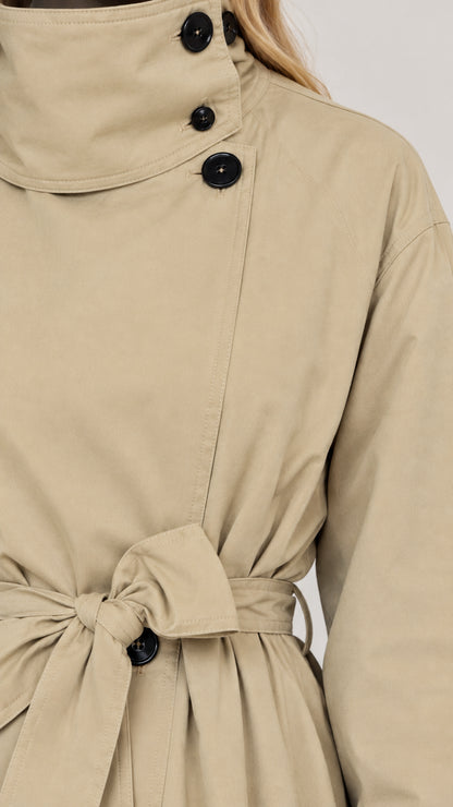 Close-up detail of beige trench coat collar buttons and waist belt