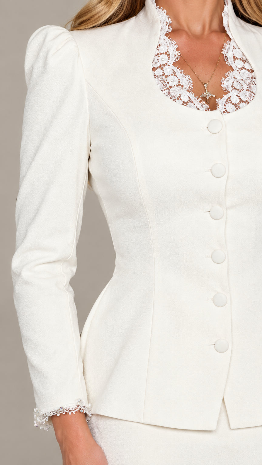 Close-up detail of white jacket neckline with lace trim and covered buttons