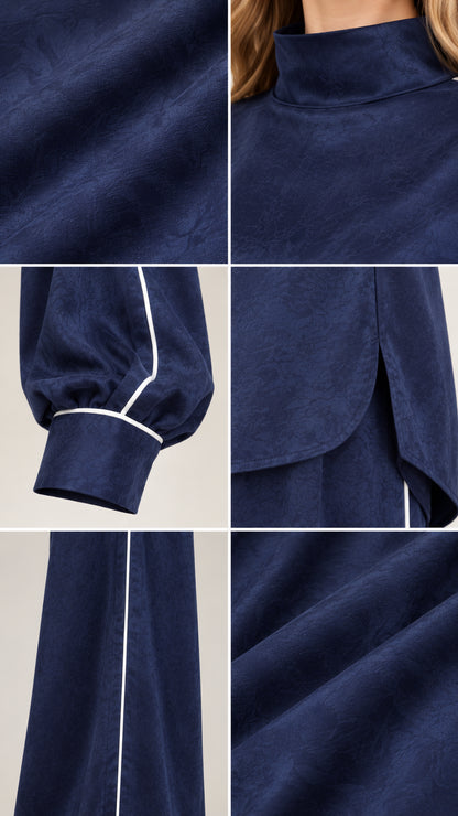 Close-up details of navy blue mock neck collar, cuffed sleeve with piping, slit hem, and fabric texture