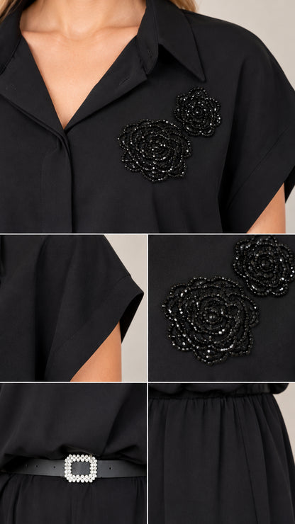 Close-up details of collar, beaded floral brooch, and crystal belt buckle on black jumpsuit