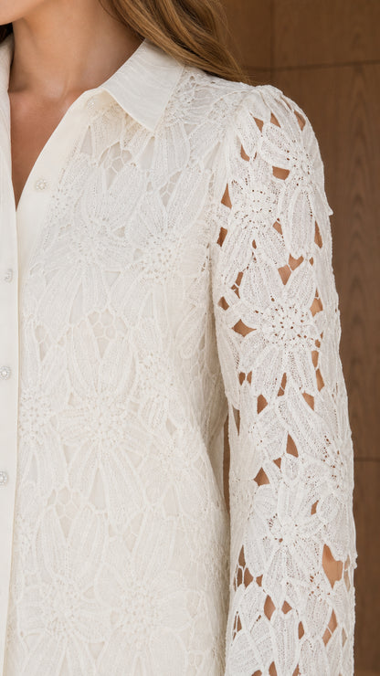 Close-up detail of sheer floral lace texture, pointed collar, and buttons on ivory shirt