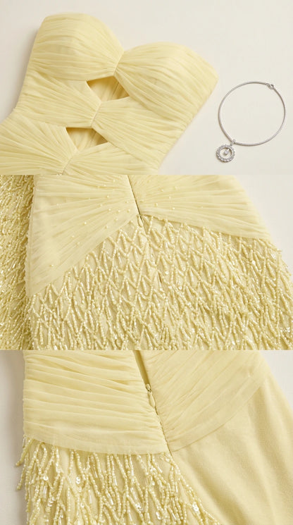 Close-up detail of pale yellow ruched fabric, front cutouts, and textured embellishment