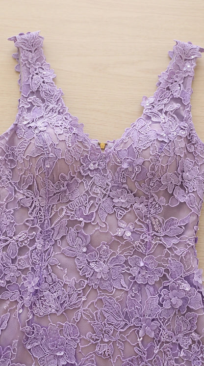 Close-up detail of lavender floral embroidered lace fabric and scalloped neckline