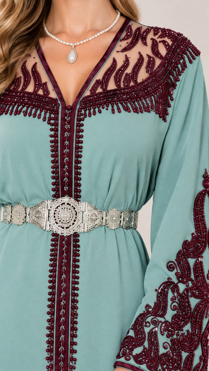 Close-up detail of V-neckline, illusion embroidery, trim, and ornate metallic belt on Sage Green caftan