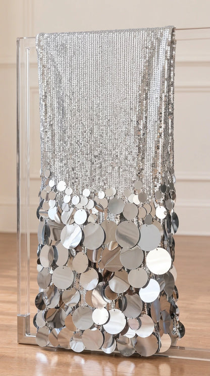 Close-up detail of silver sequined fabric transitioning to large disc paillettes