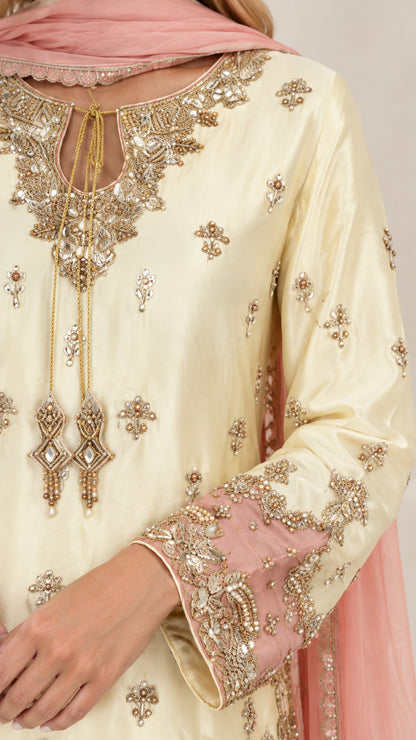 Close-up detail of embroidered neckline with gold tassels and embellished cuffs