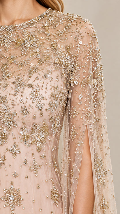 Close-up detail of intricate beading and sequin starburst pattern on champagne cape sleeve dress