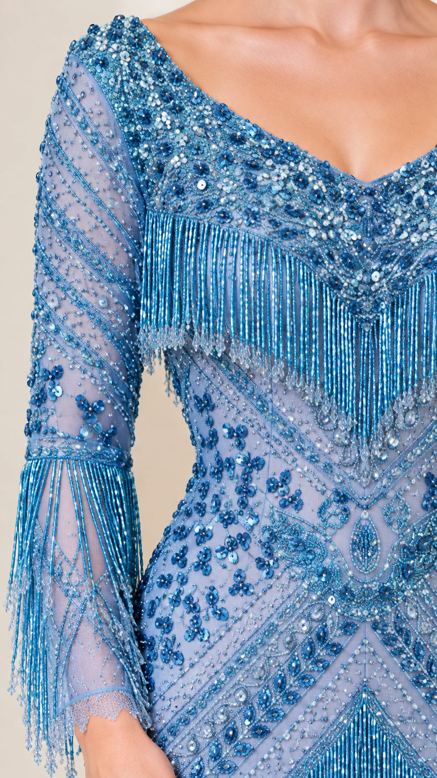 Close-up detail of sheer long sleeve, chevron beadwork, and layered fringe accents