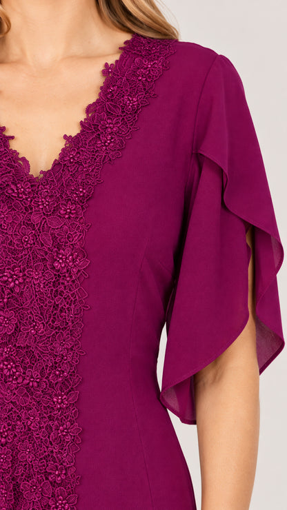 Close-up of intricate lace embroidery along V-neckline and flutter sleeve