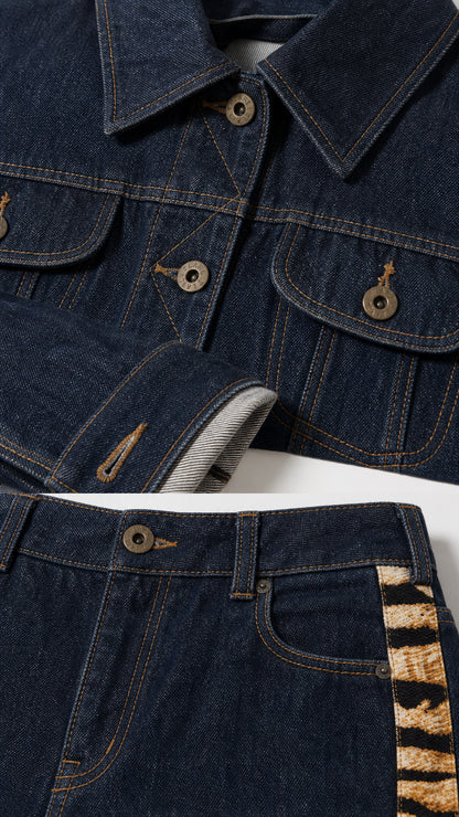 Close up detail of Dark Blue denim jacket buttons and flare pants waistband with animal print trim