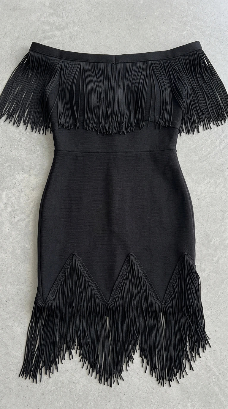 Flat lay view showing neckline and hem fringe details on black dress