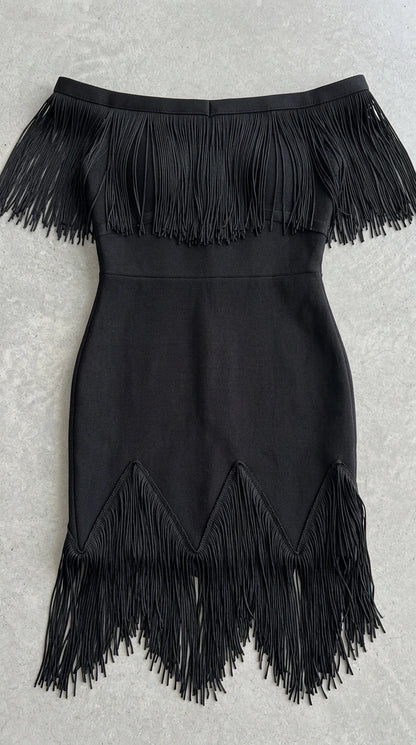 Flat lay view showing neckline and hem fringe details on black dress