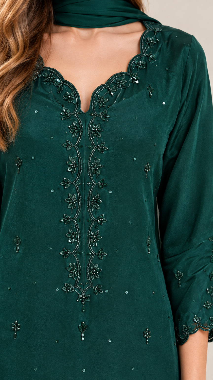 Close-up detail of scalloped neckline featuring tonal embroidery and delicate beadwork on green tunic