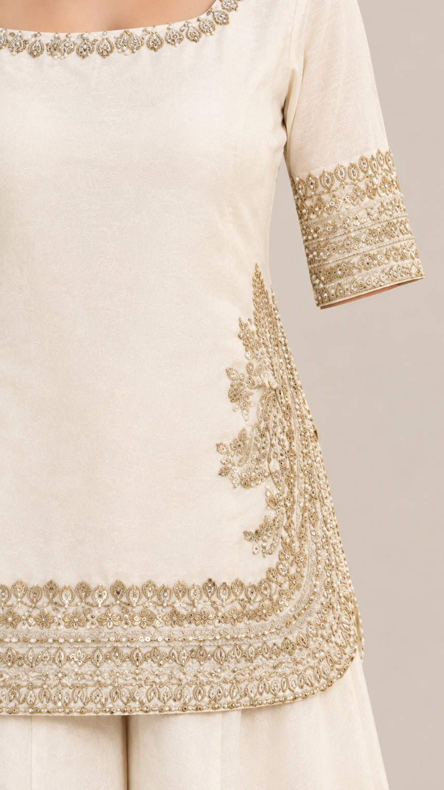 Close-up of gold metallic embroidery on ivory kurti neckline and hem