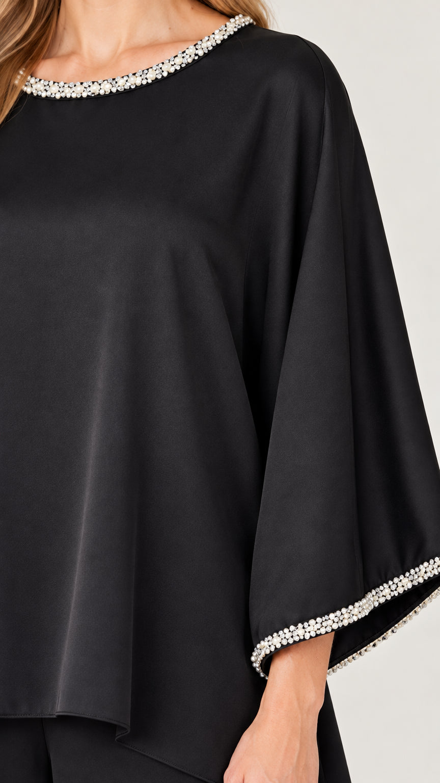 Close-up detail of sparkling crystal-beaded trim on neckline and sleeve cuffs