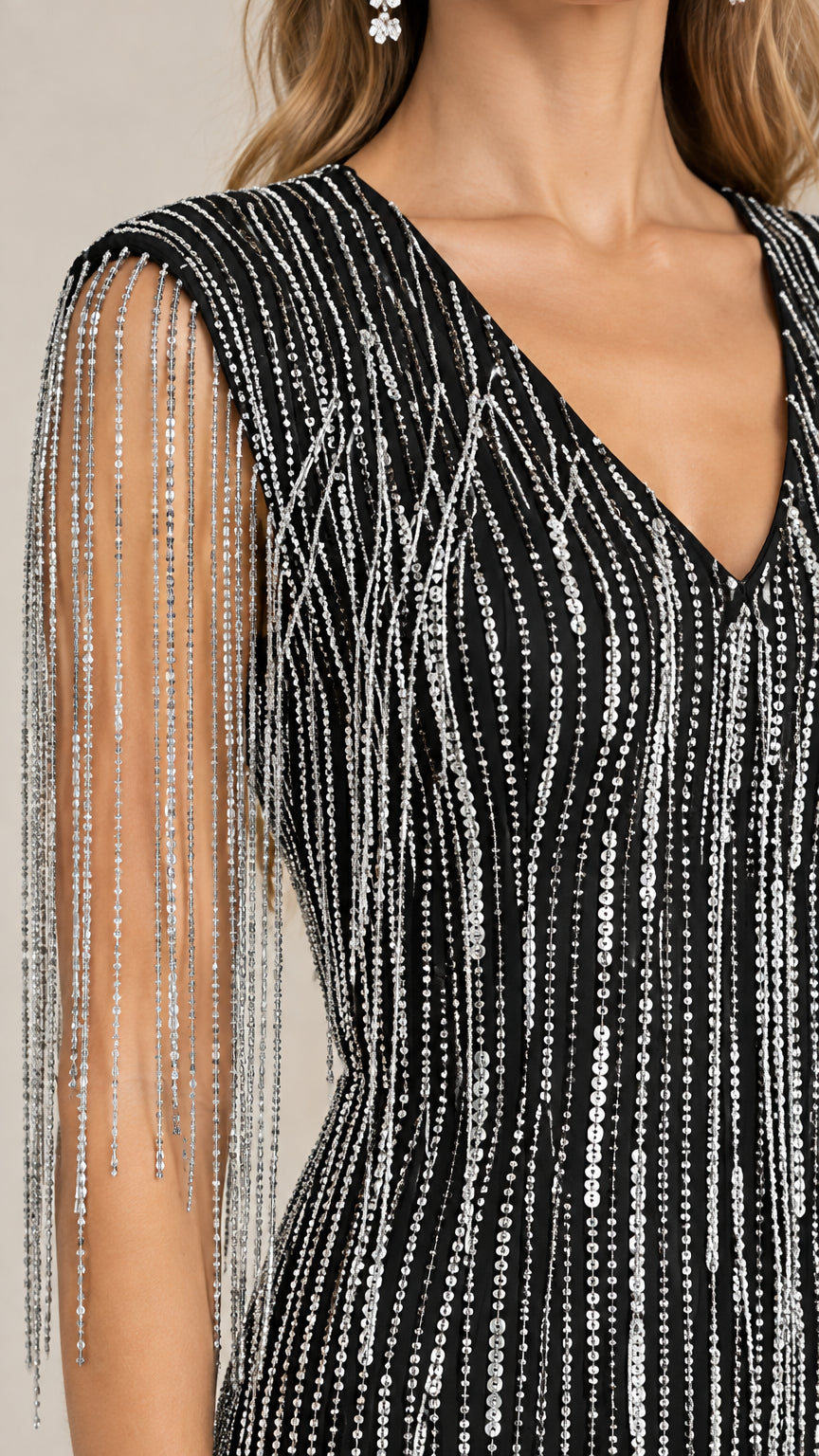 Close-up detail of silver beaded fringe and sequin embellishments on black dress