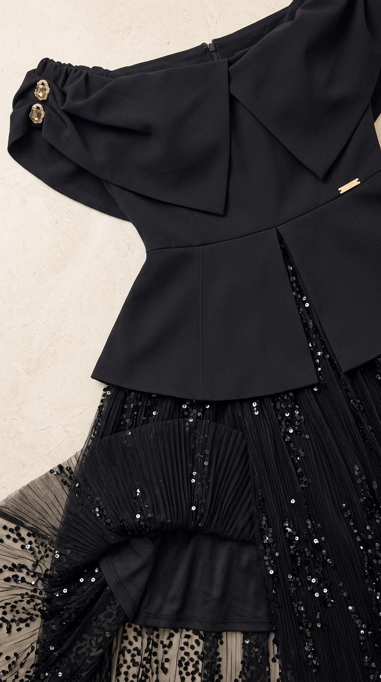 Close-up detail of structured bodice, foldover neckline, gold buttons, and sequin skirt
