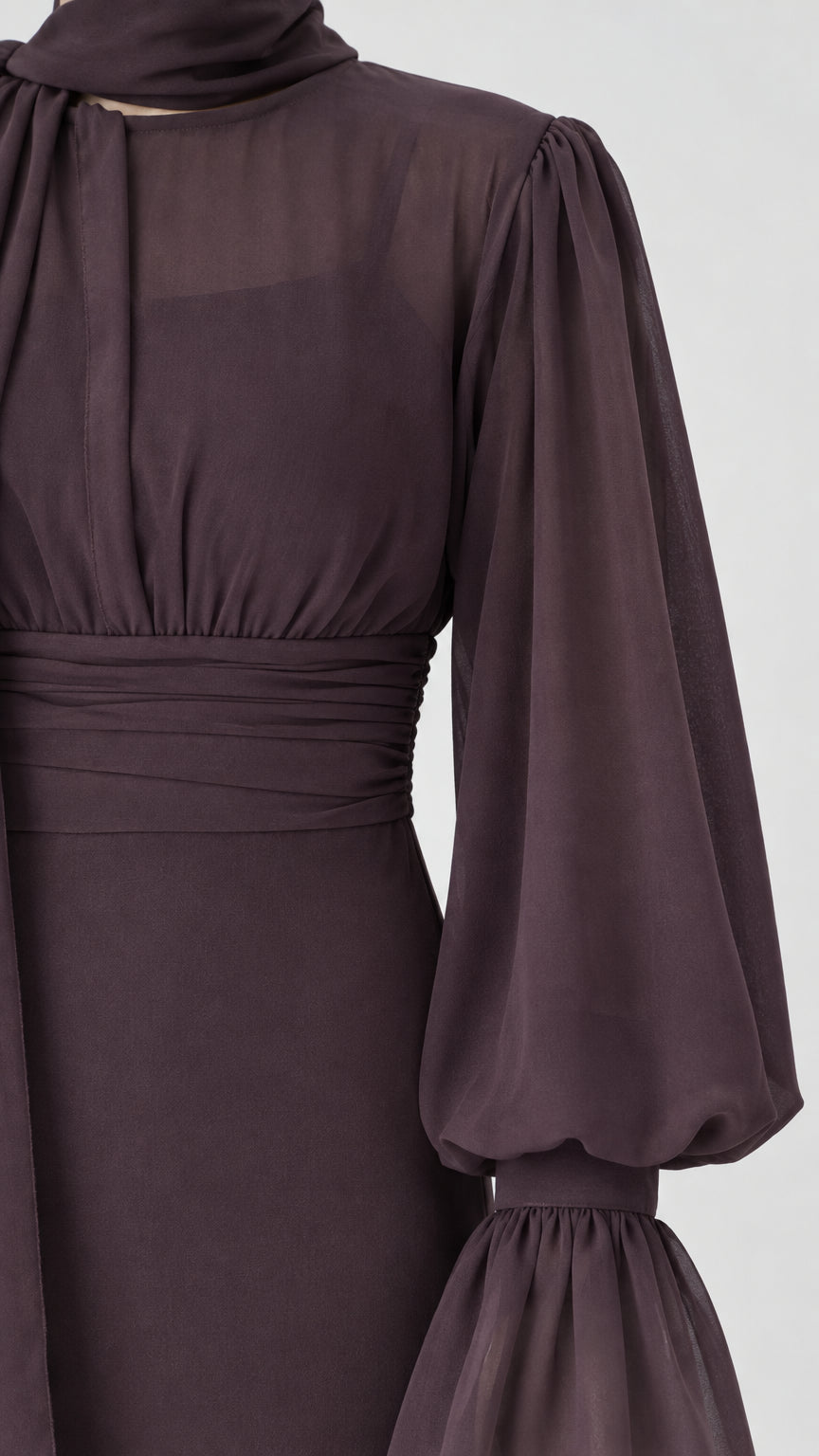 Close-up detail of sheer balloon sleeve, ruffled cuff, and ruched waist on Chocolate Brown jumpsuit