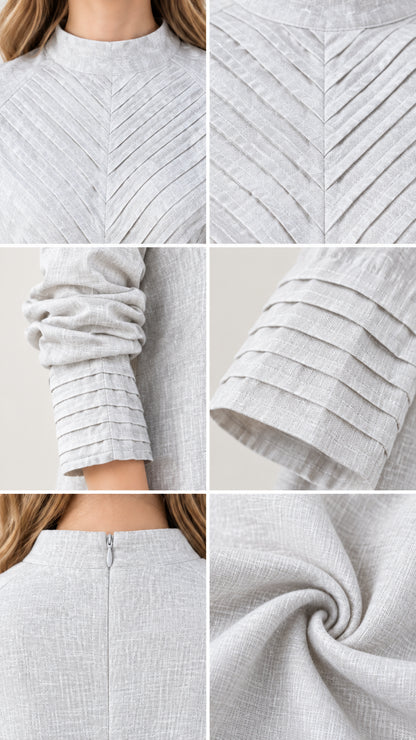 Close-up details of chest chevron pleating, pleated cuff, zip, and woven fabric texture