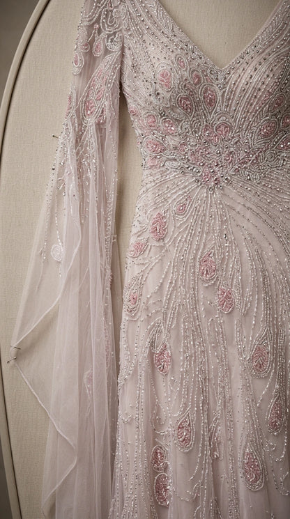 Close-up detail of sheer fabric, delicate pink beadwork, and sparkling sequins on gown